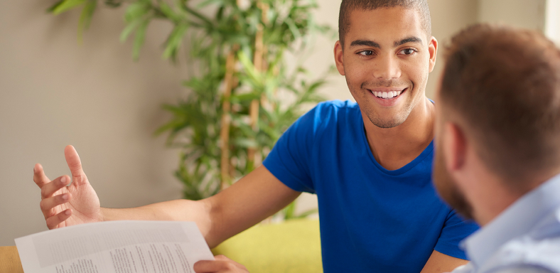 A student holding a form talks with a counselor